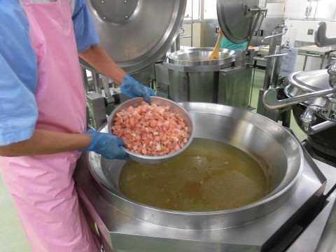 鶏肉をだしに入れる様子