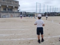 ソフトボール投げのボール拾いをする児童