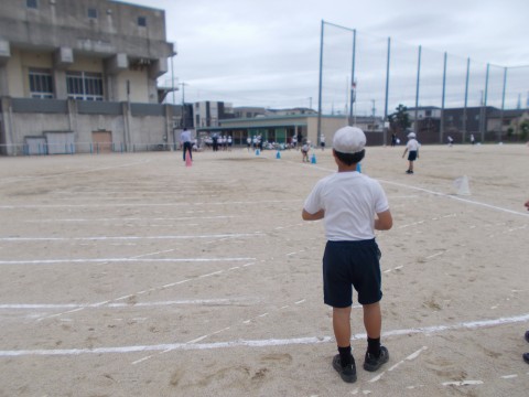 ソフトボール投げのボール拾いをする児童