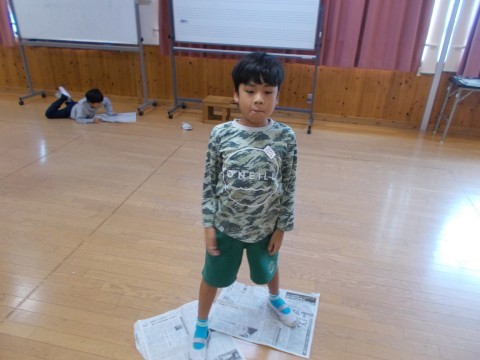 新聞紙の上に立つ児童